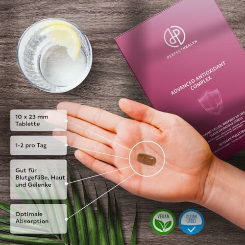 Hand hält Tablette neben Supplement-Verpackung.